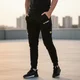 Spodnie dresowe unisex W-TEC Signature ∙ krój cargo ∙ praktyczne kieszenie ∙ gumowy pas ∙ miękki materiał ∙ idealne na trening i relaks - Czarny - Czarny